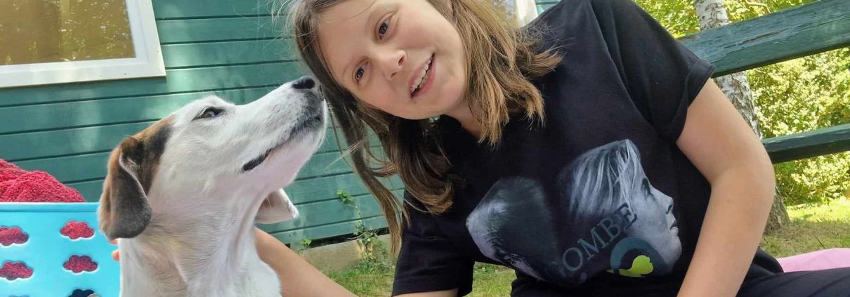 Hund und Kind sitzen entspannt nebeneinander